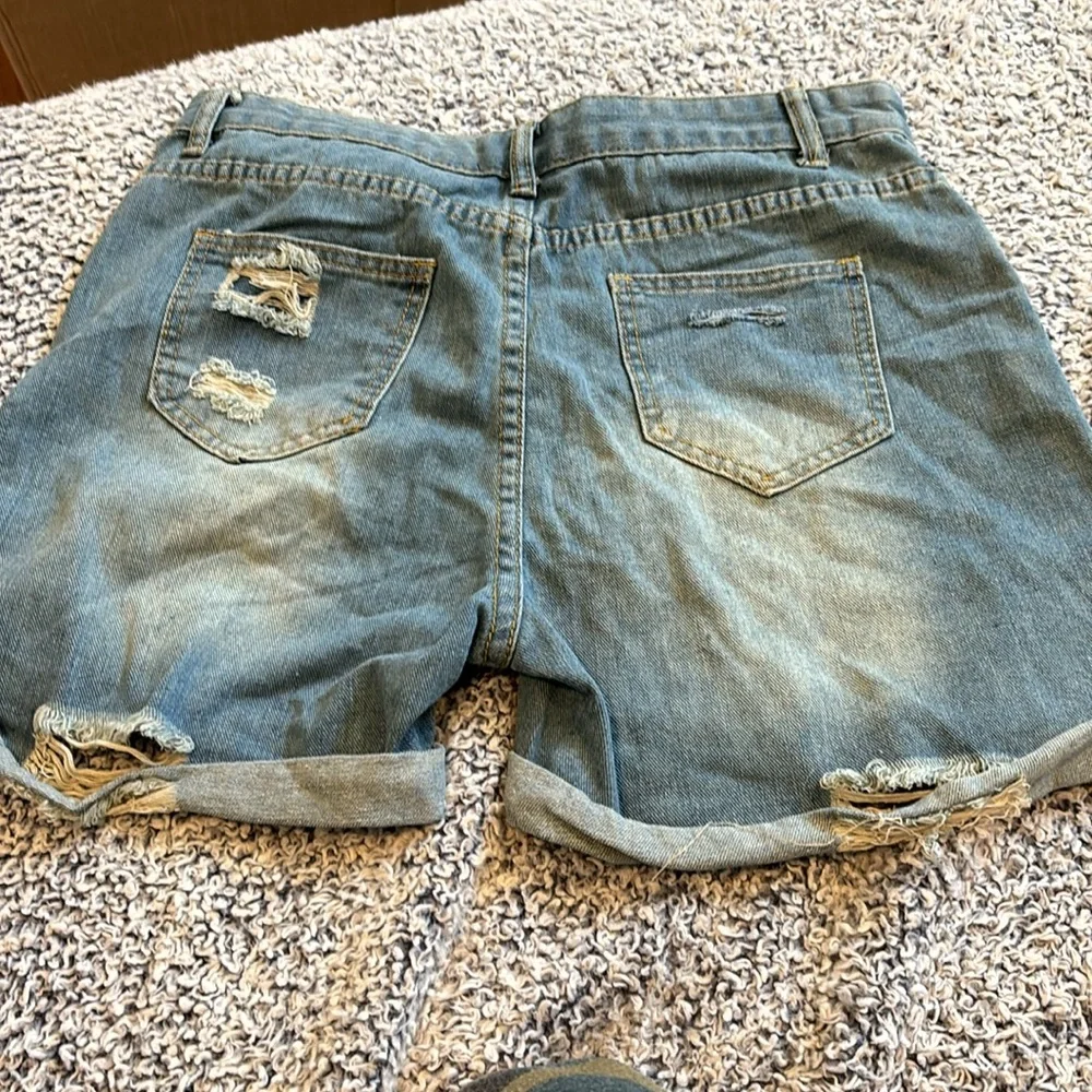 Large light blue soft denim cuffed jean shorts with shredded holes. - Picture 3 of 4